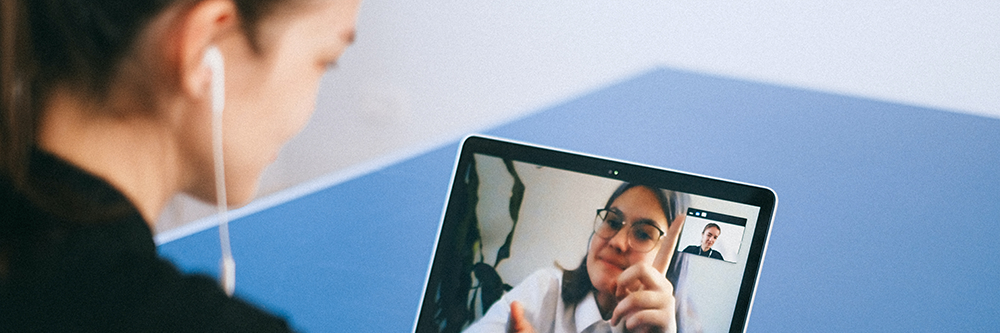 Two people talking through a laptop.